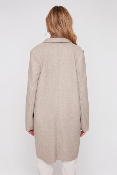 Back view of a woman wearing a long heather latte brushed knit coat with raw edge detailing.