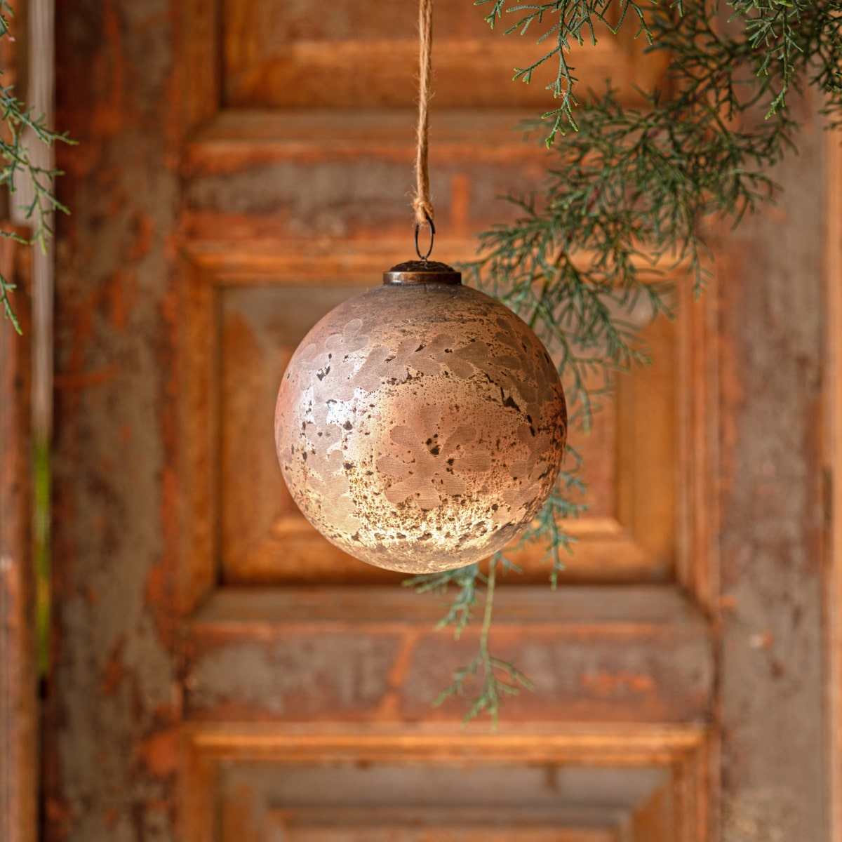 Cameo antique foil glass etched 5-inch ball ornament hanging from a twine string.