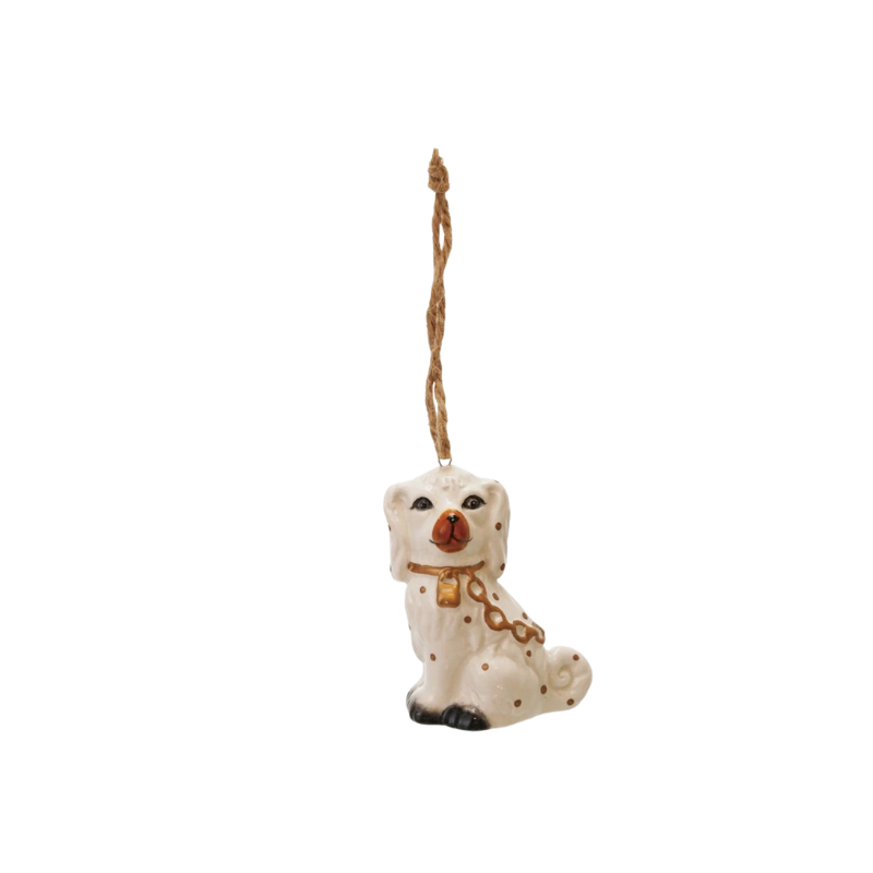 White ceramic Staffordshire dog ornament with gold details and a jute hanging string.