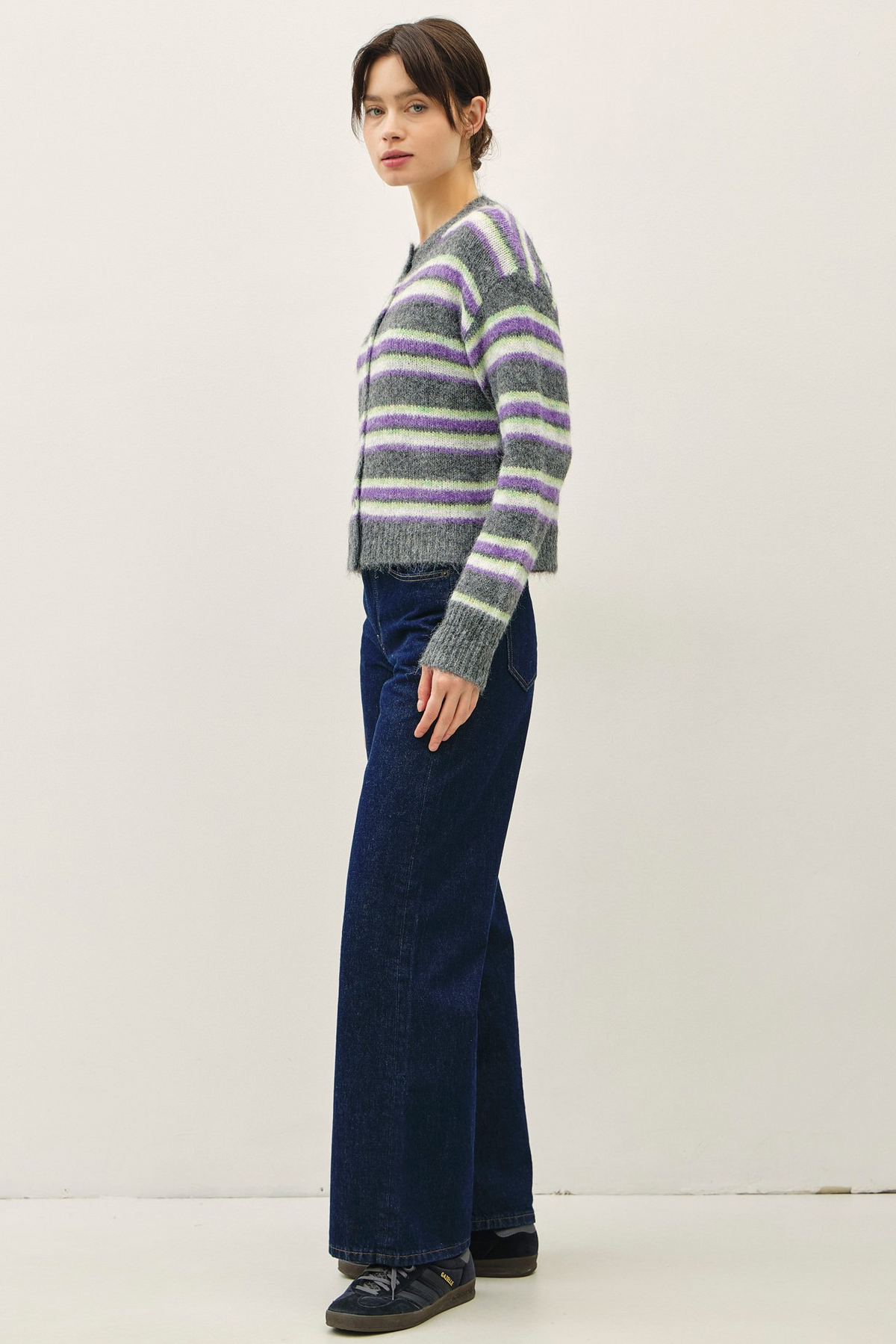 Woman wearing a Chloe Striped Button Up Cardigan in charcoal with purple and green stripes.