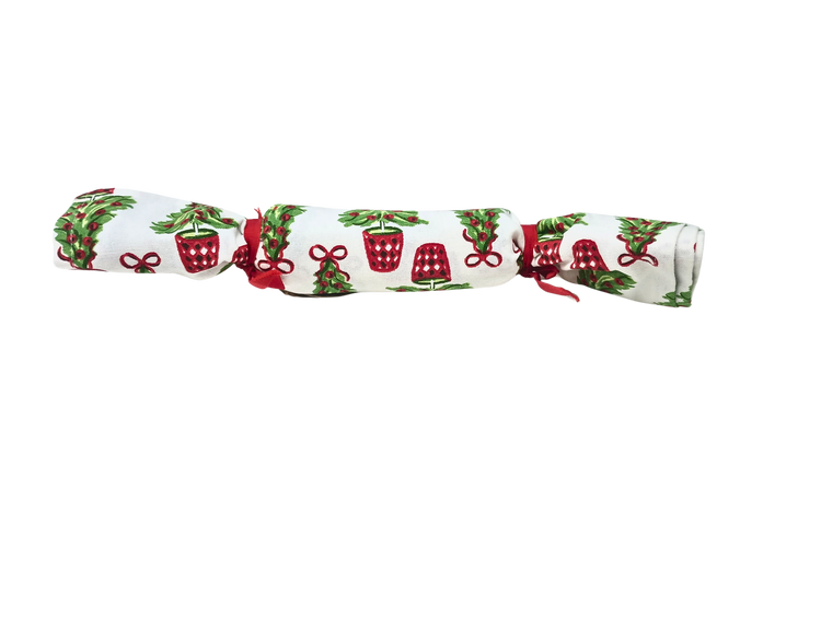 Rolled Christmas block print cotton towel with green tree and red pot design tied with red ribbons.