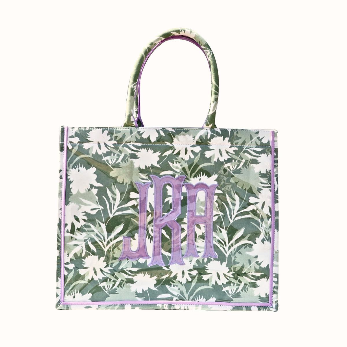Sage green floral tote bag with purple monogram and trim, featuring white flower patterns.