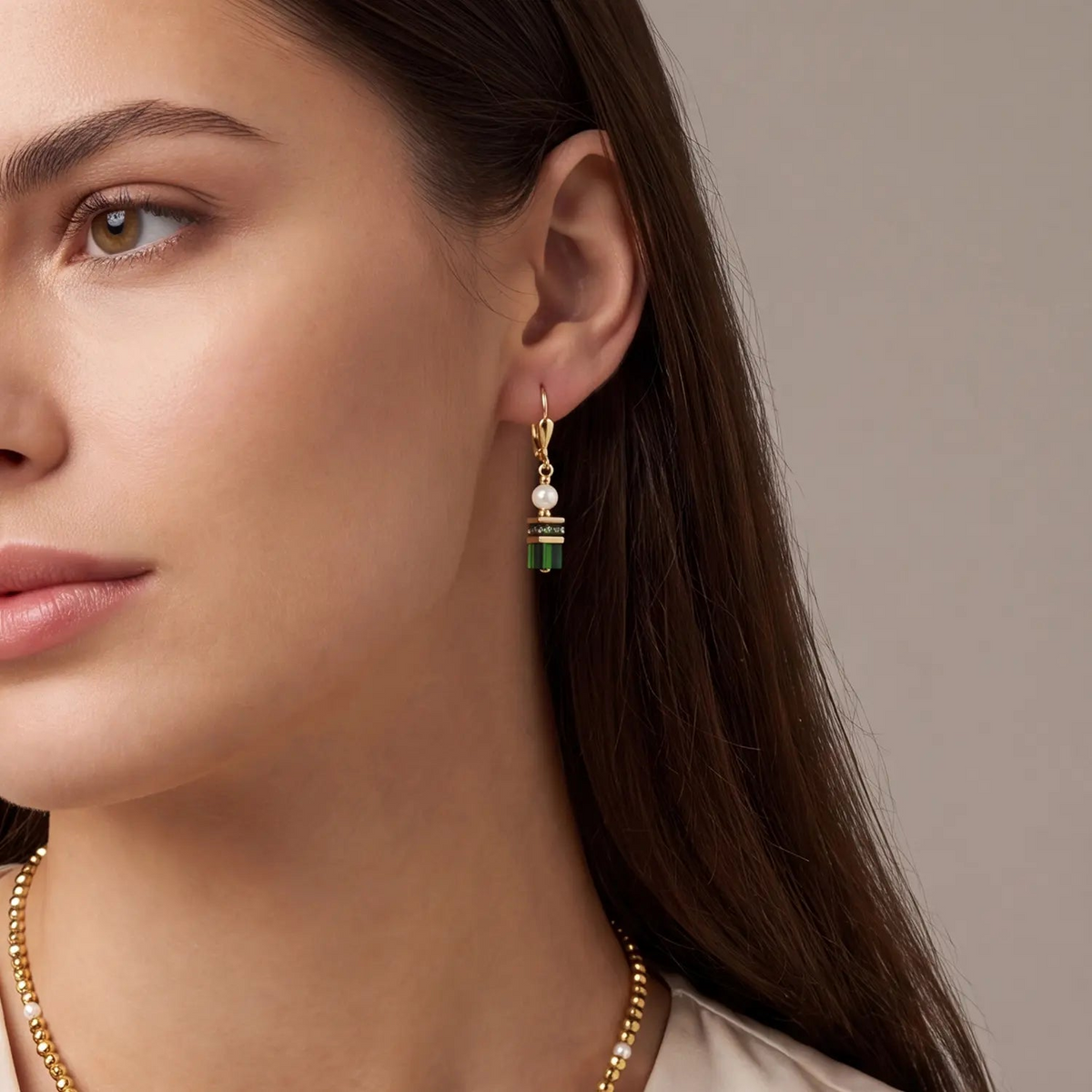 Earrings Sparkling Princess Gold-Emerald with Swarovski pearls and green crystals on a model.