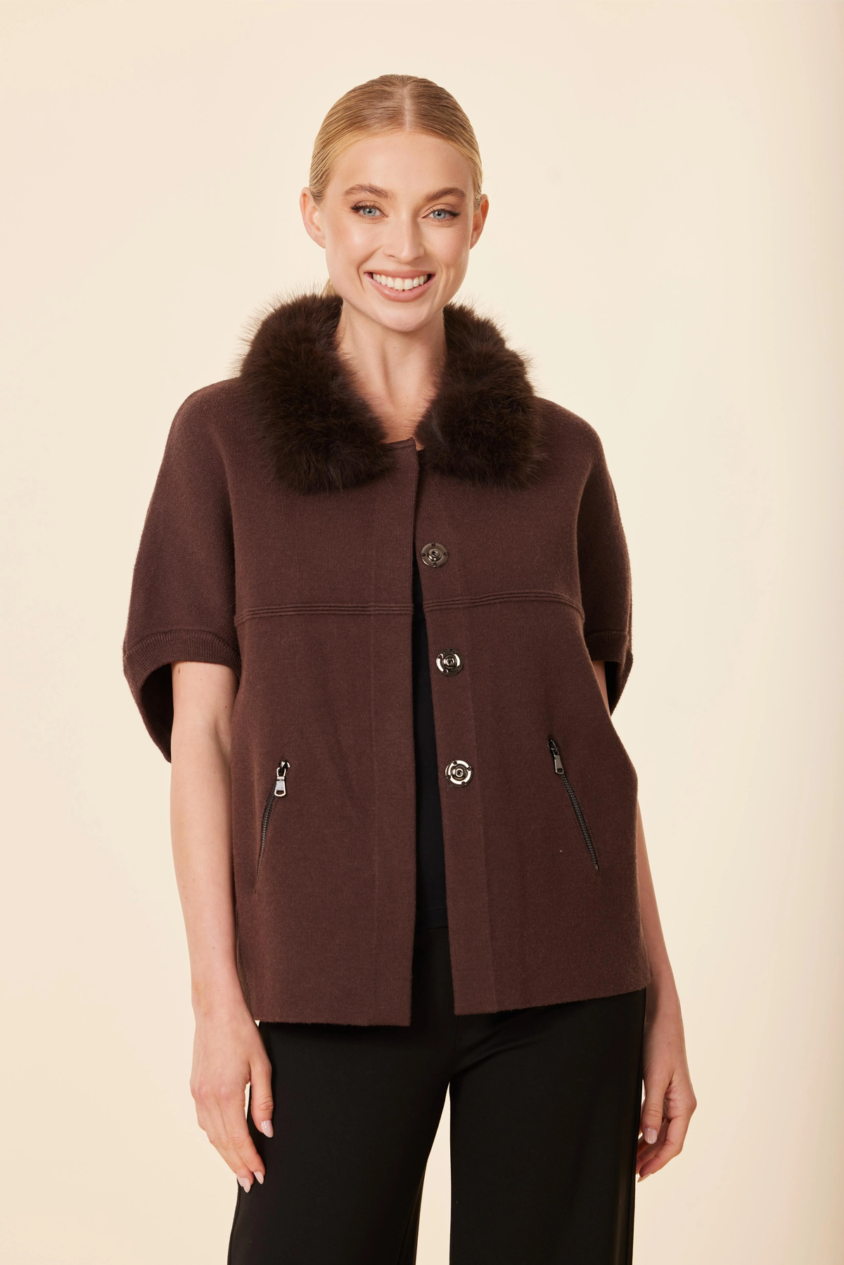 Woman wearing the Emilia Faux Fur Trim Cardigan in brown with short sleeves and snap closures.