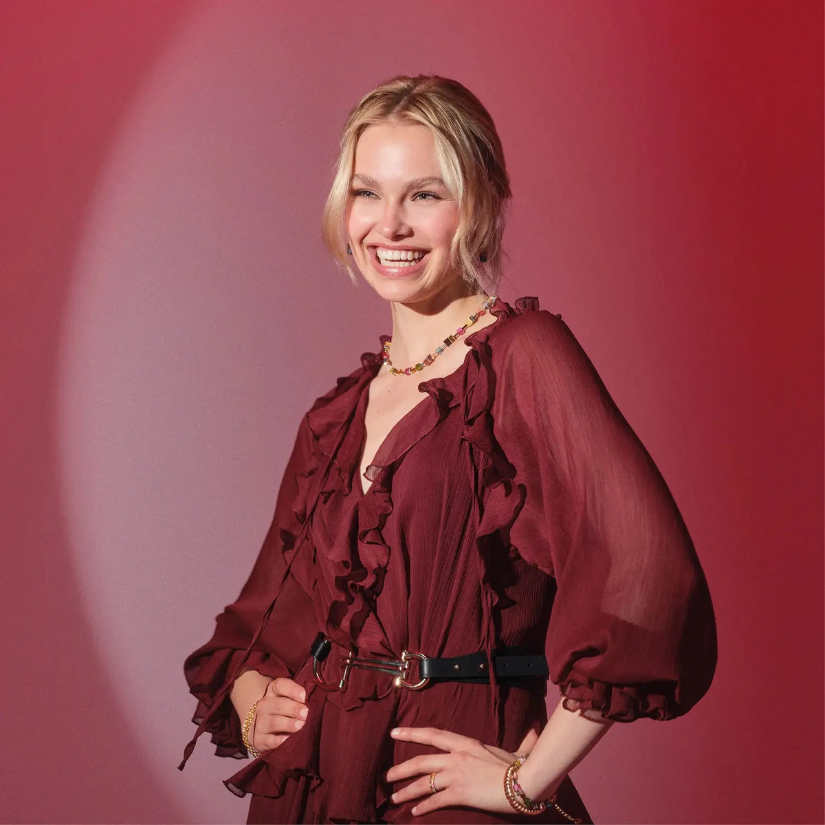 Woman wearing the GeoCUBE Iconic Necklace Multicolor Joy Gold with a burgundy ruffled dress.