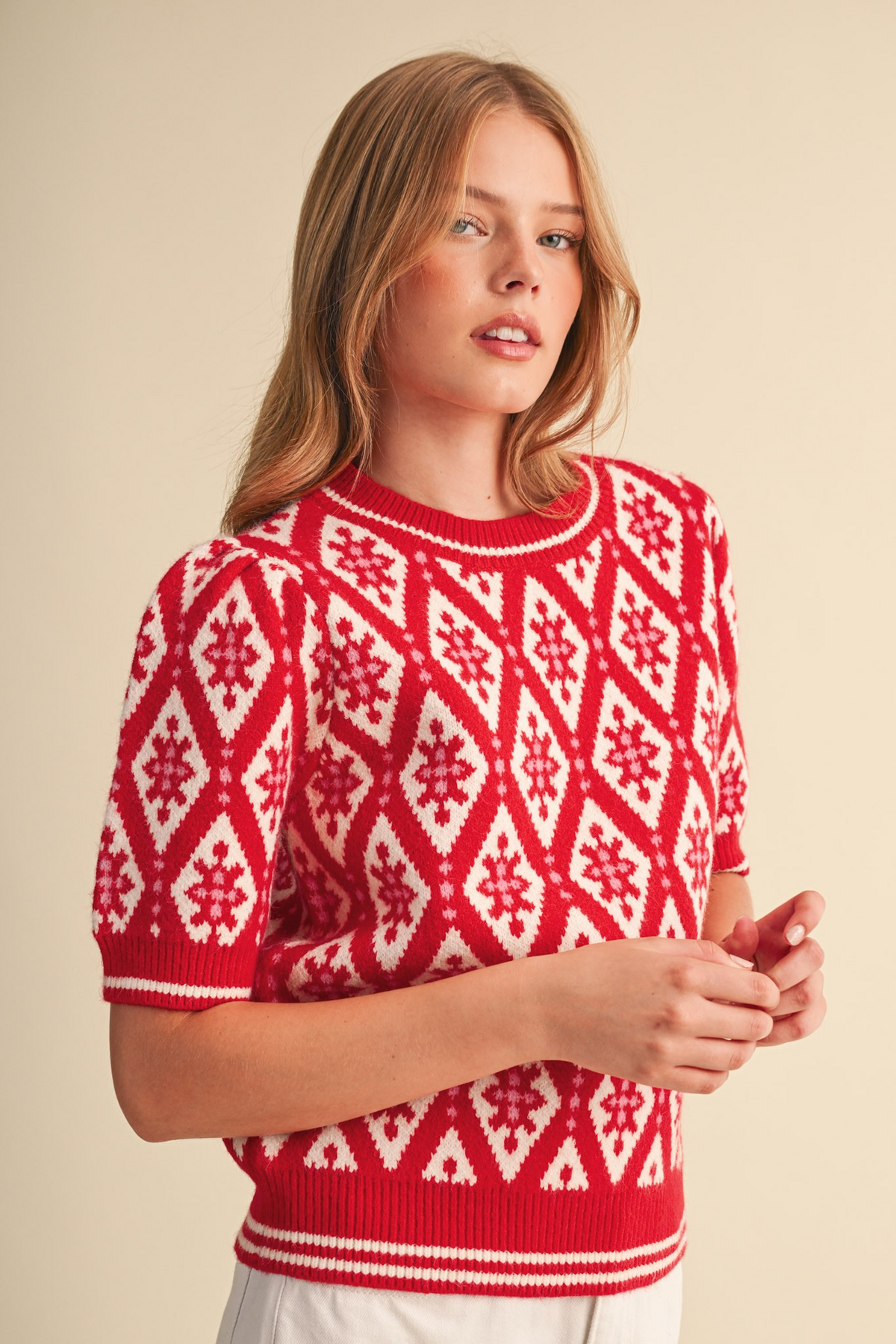 Woman wearing the Isabella red and white geometric knit short sleeve sweater with ribbed trim.