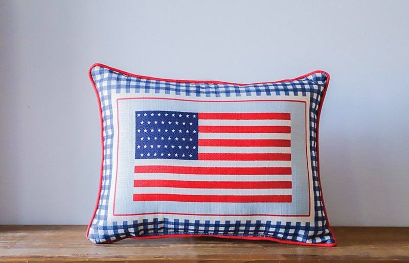 Rectangular pillow with an American flag design and a blue and white gingham border.