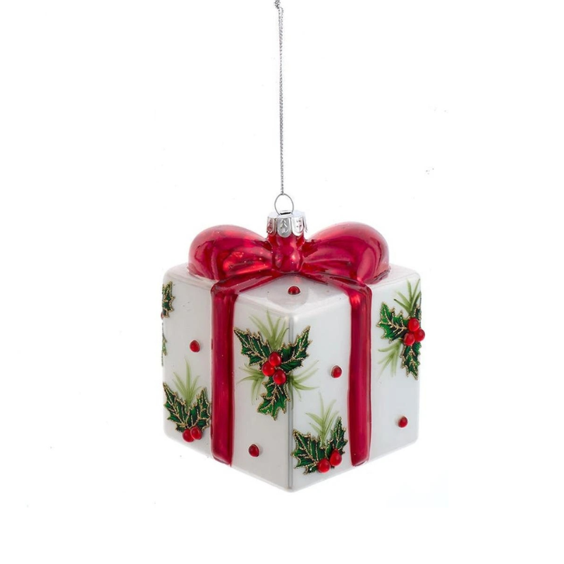 Glass present ornament with a red bow and holly leaf decorations on a white background.