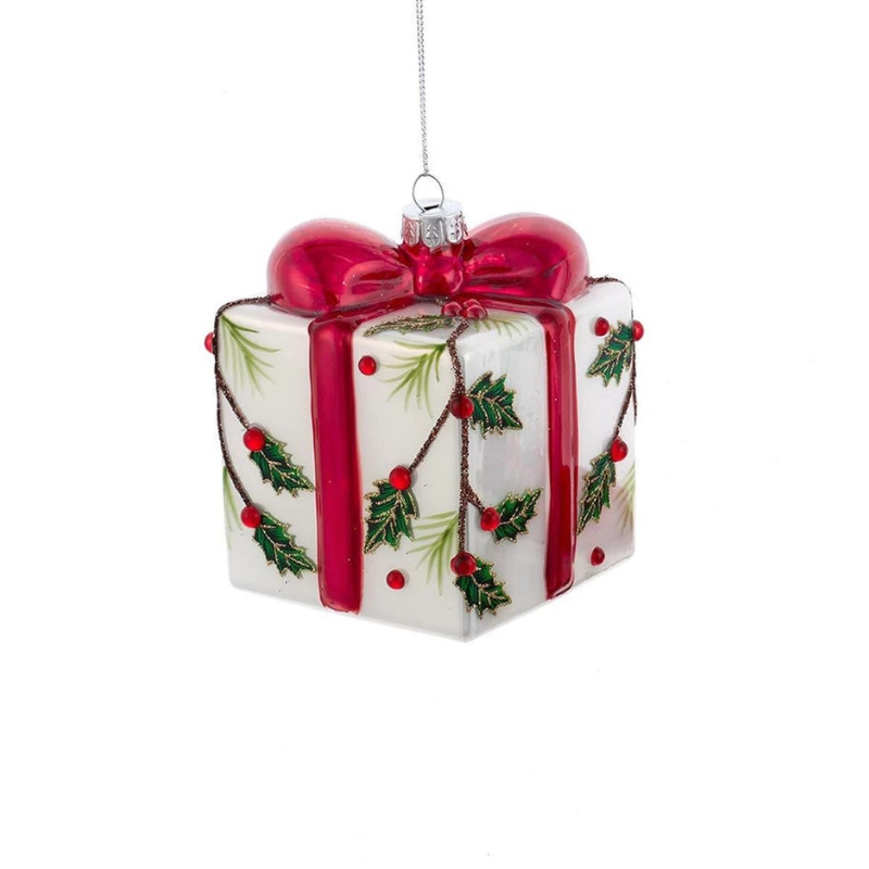 Glass present ornament with a red bow, holly leaves, and red berries on a white background.