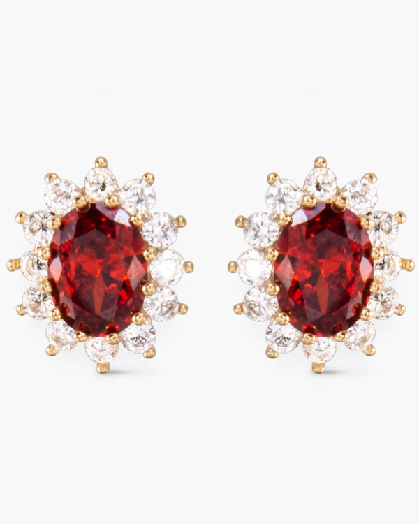 Pair of gold stud earrings featuring oval red center stones surrounded by clear CZ halos.