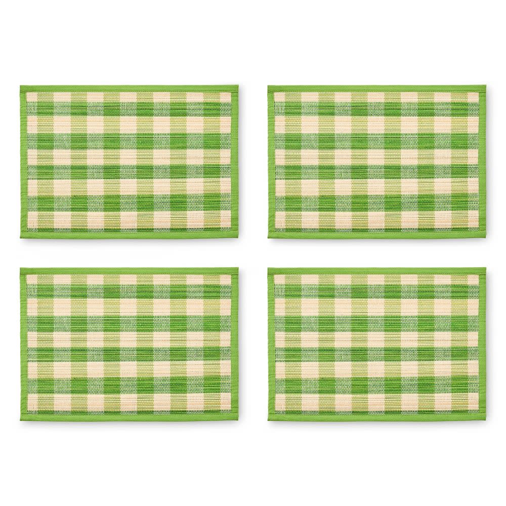 Green woven straw placemat with cotton trim in a checkered pattern.