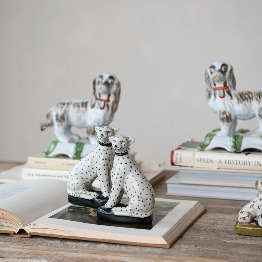 Set of two hand-painted vintage reproduction stoneware cheetah figurines with black spots.