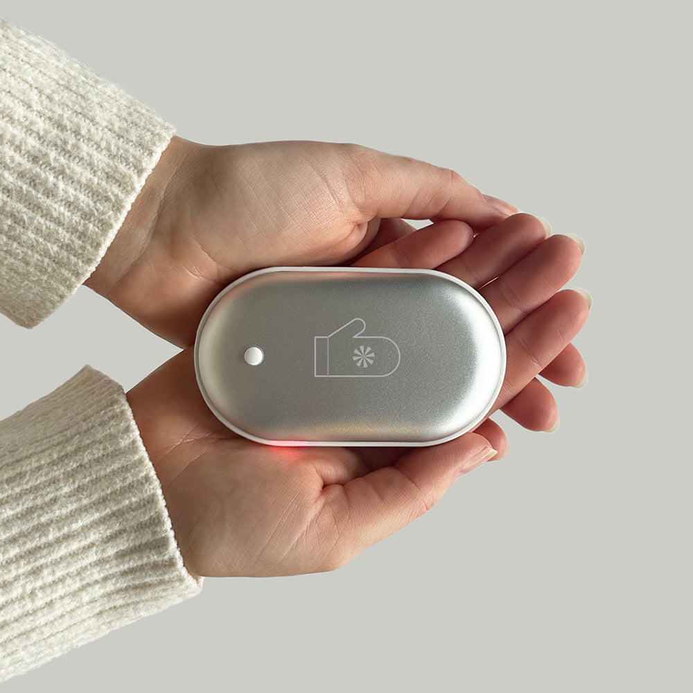 Silver oval hand warmer with a mitten icon and a small indicator light.