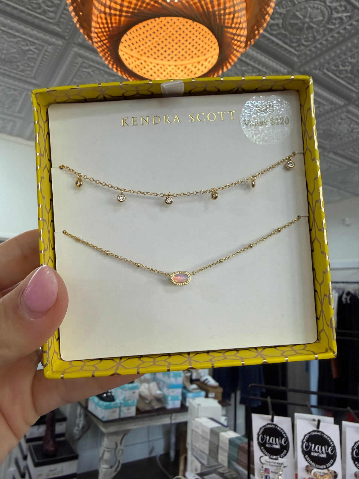 Kendra Scott gift set with a gold chain necklace and a pink opalite pendant necklace in a box.