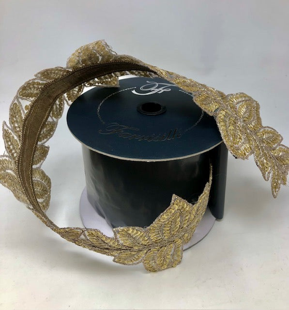 4 inch wide gold masquerade vine ribbon with metallic leaf patterns on a black spool.