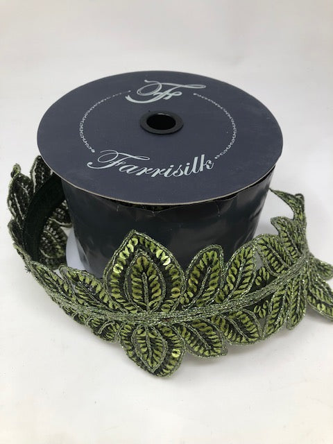4 inch by 5 yard Masquerade Vine Olive Ribbon with green sequined leaf patterns on a spool.