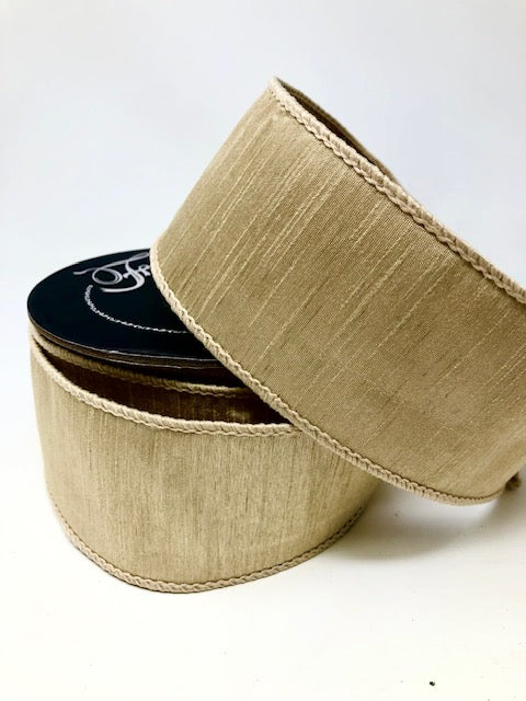 2.5 inch wide beige dupion ribbon with a textured finish and stitched edges on a spool.
