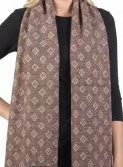 Brown knitted scarf with a repeating white diamond pattern worn over a black long-sleeve shirt.