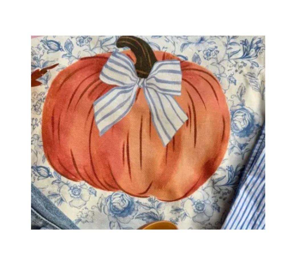 Close-up of an orange pumpkin graphic with a blue and white striped bow on a blue floral background.
