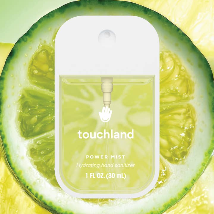 Touchland Power Mist Hydrating Hand Sanitizer in a clear spray bottle against a lime slice backdrop.