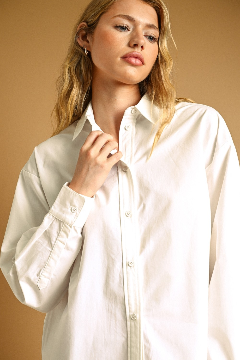 Woman wearing a white Eunice Long Sleeve Buttondown Shirt with a relaxed, oversized fit.
