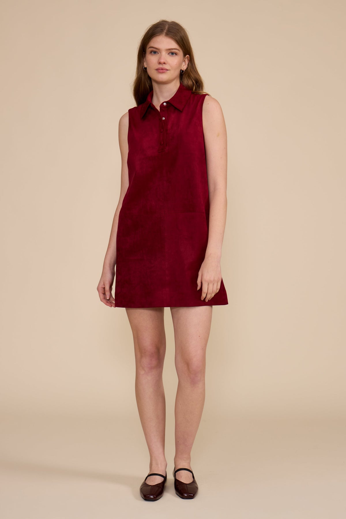 Model wearing the Amanda Mini Dress in deep merlot, a sleeveless faux suede dress with a collar.