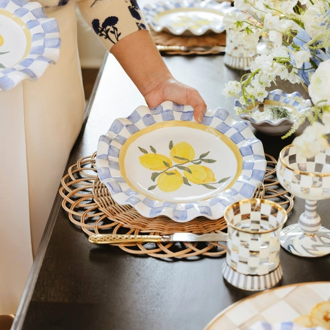 Ceramic cheese platter with a scalloped edge in cream color featuring a subtle floral pattern.