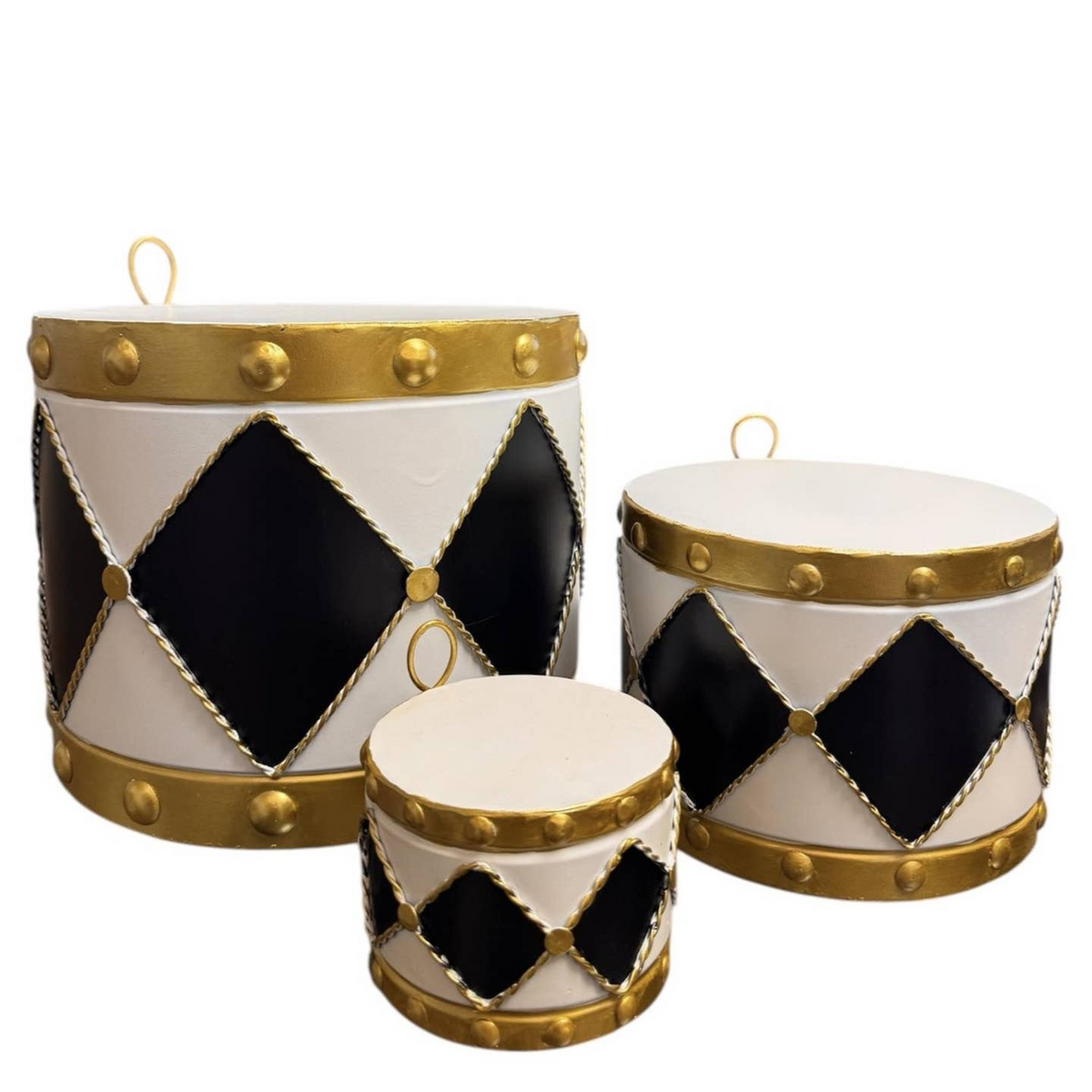 Set of three graduated metal drum ornaments in black and white with gold trim and diamond patterns.