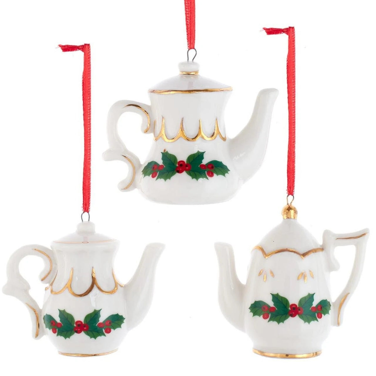 Three white porcelain teapot ornaments with gold trim, holly leaf designs, and red hanging ribbons.