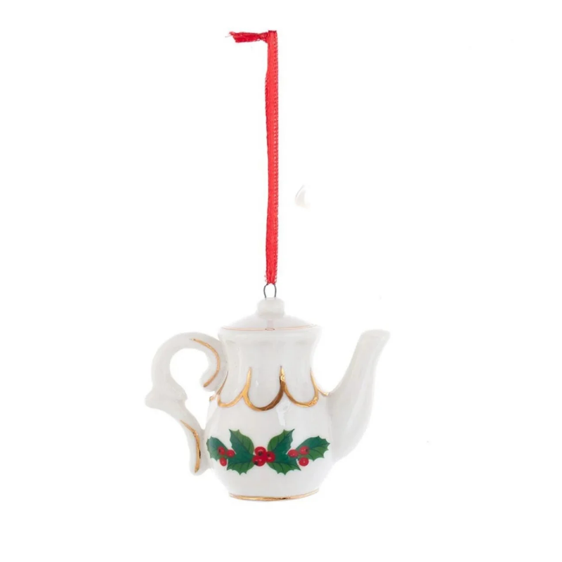 White porcelain teapot ornament with gold trim, holly leaf design, and a red hanging ribbon.