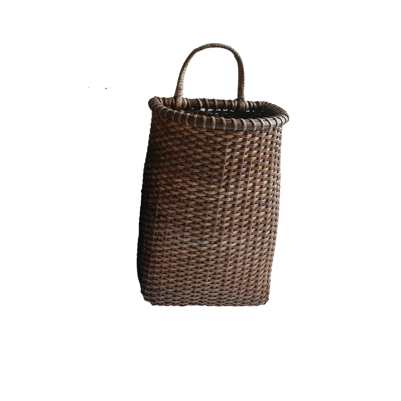 Dark brown woven rattan door basket with a single curved handle for hanging.