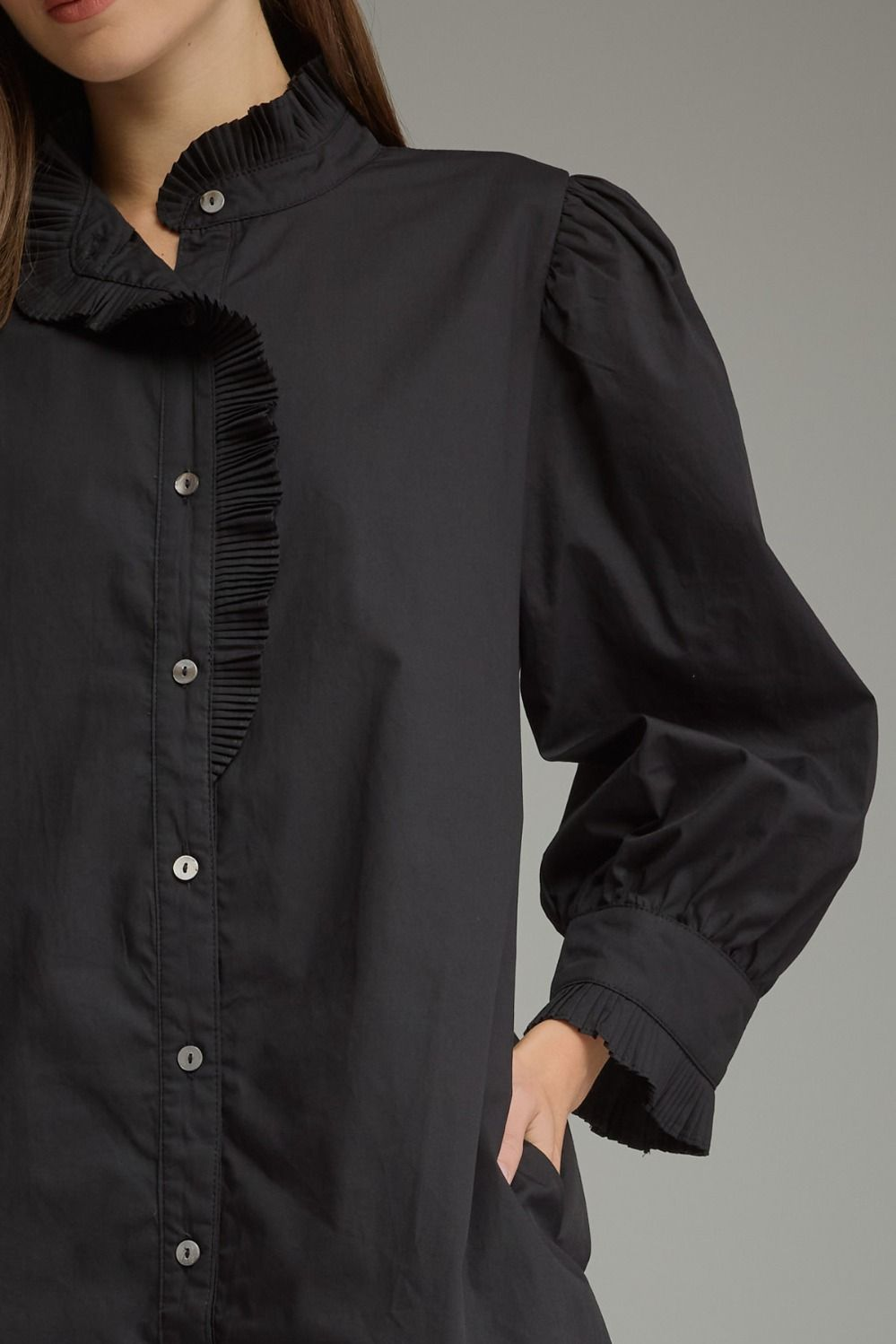 Close-up of a black Agnes mini dress featuring a ruffled high neckline and puff sleeves.