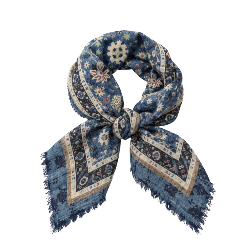 Navy blue tapestry print wool square scarf knotted in the center with frayed edges.