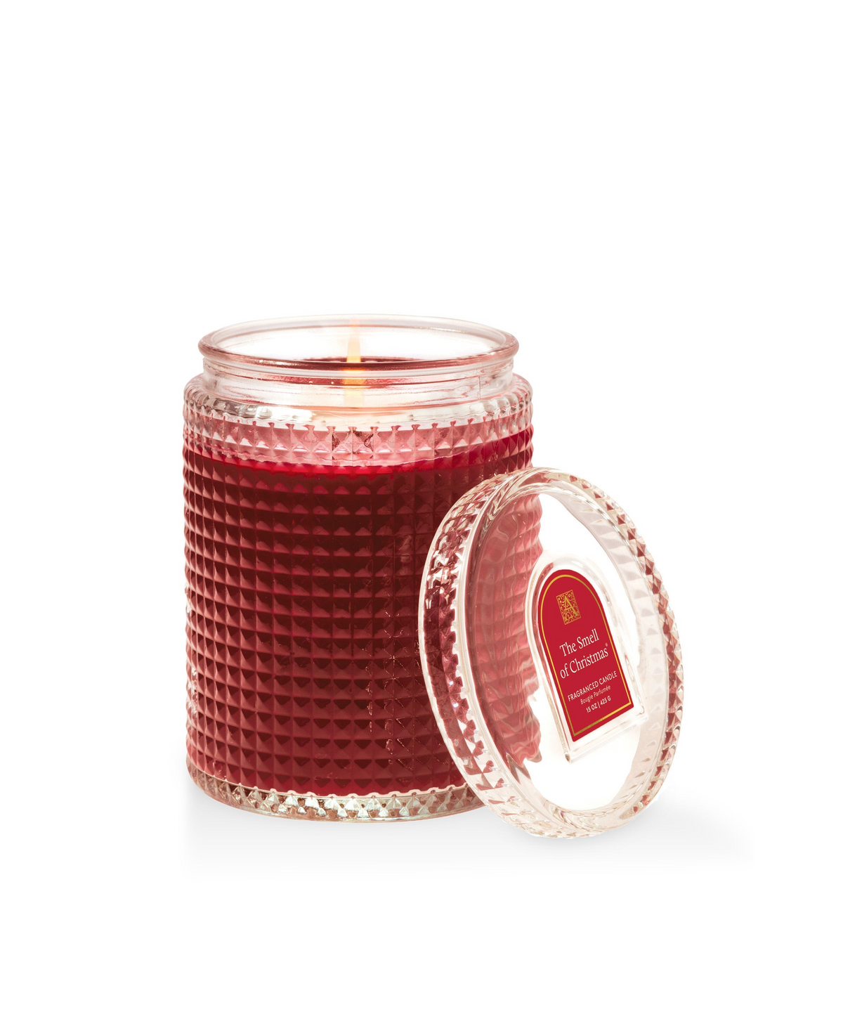 The Smell of Christmas red textured glass candle with a matching lid and a lit cotton wick.