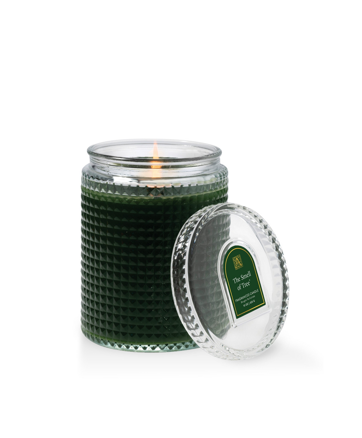 The Smell of Tree dark green candle in a textured glass jar with a lit wick and matching glass lid.