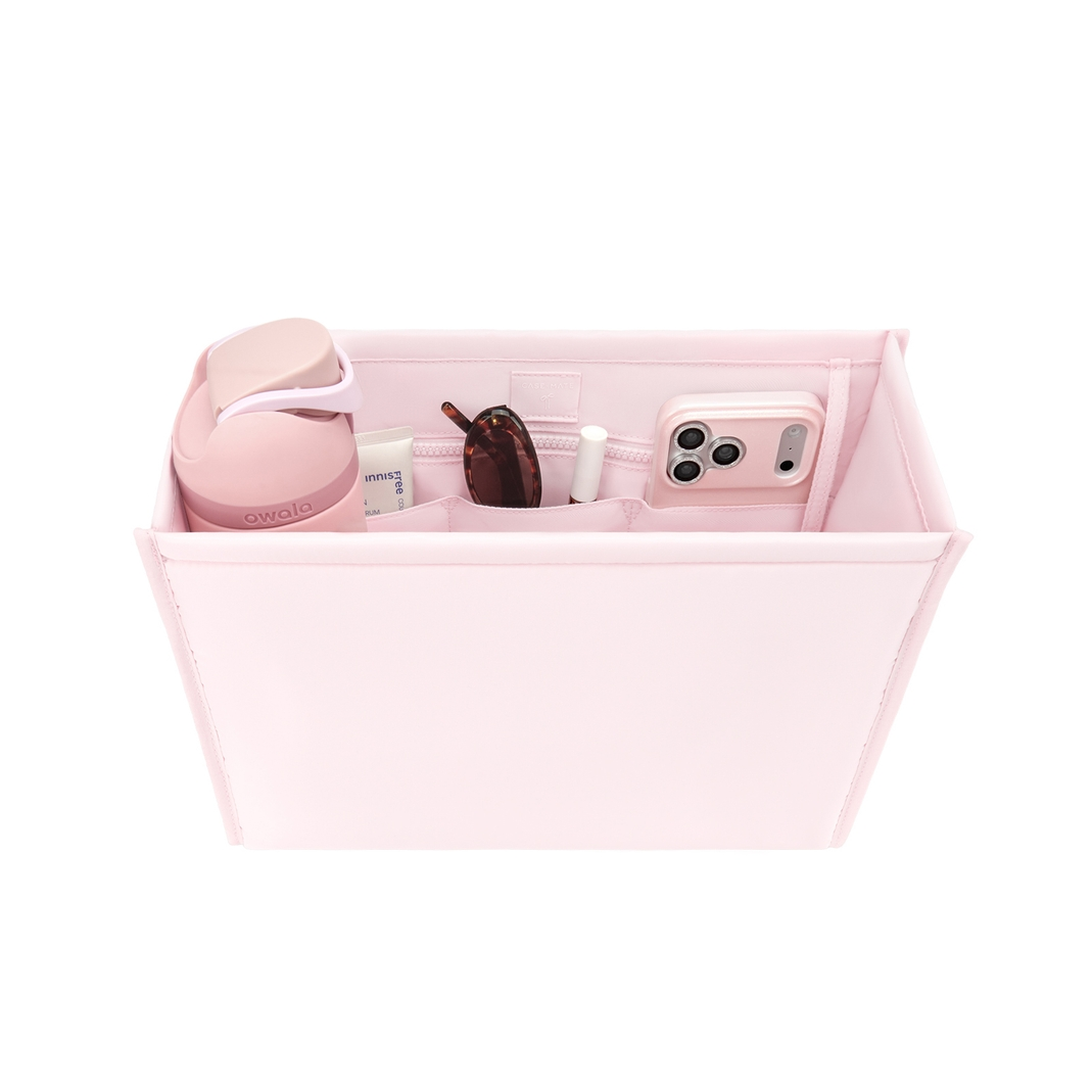 Light pink medium tote organizer insert filled with a water bottle, phone, and accessories.