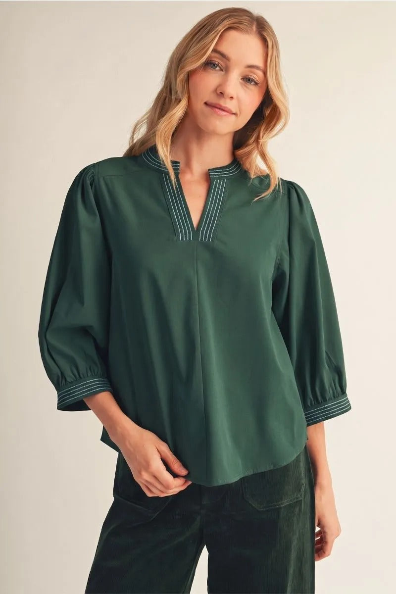 Woman wearing a forest green Trixie solid top with puff sleeves and a notched V-neckline.
