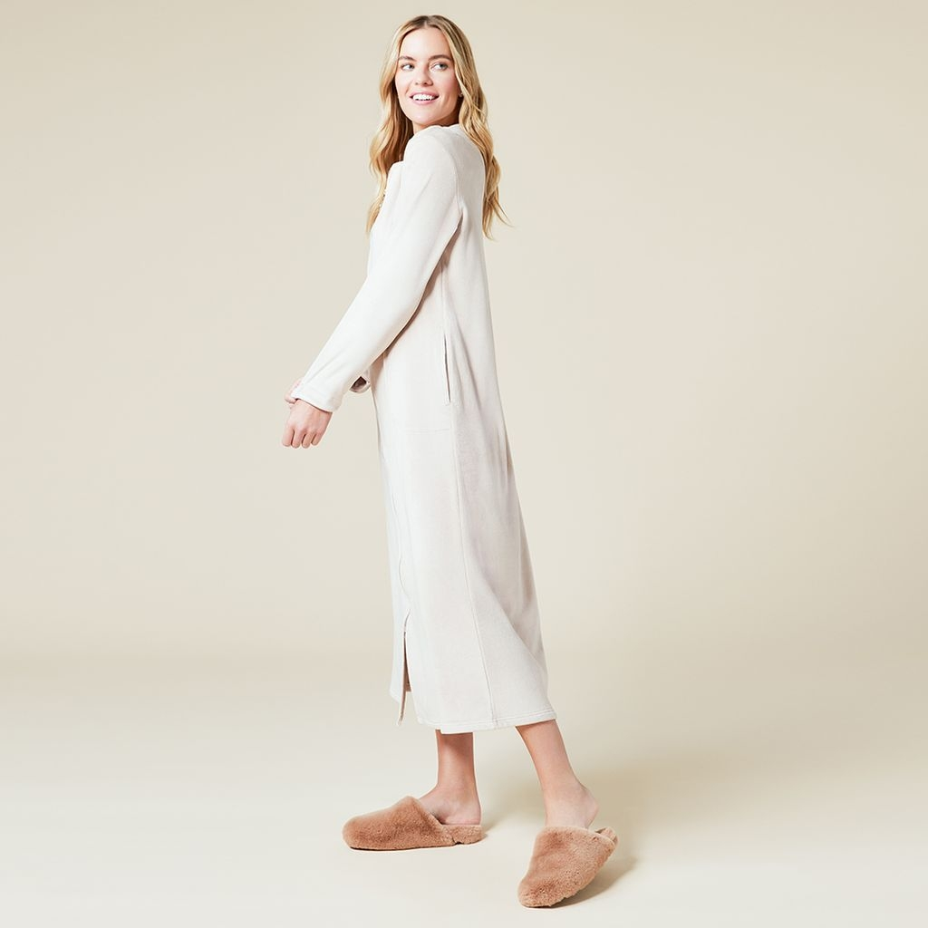 Woman in a long cream-colored Hannah Soft Zip Robe with sweetheart neckline and fuzzy slippers.