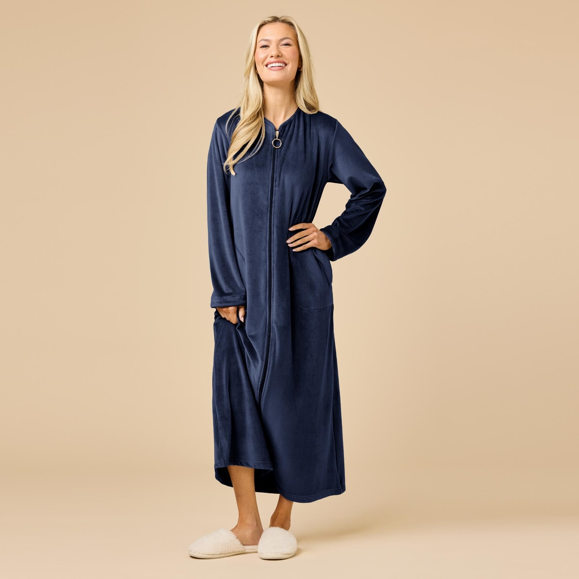 Woman wearing a navy blue Hannah Soft Zip Robe with sweetheart neckline and white slippers.