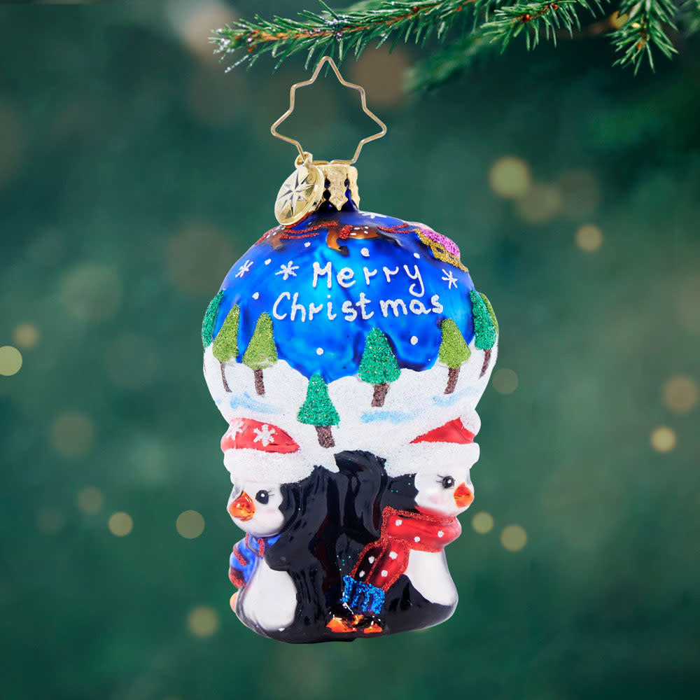 Round gem featuring three penguins with a snowy scene of Santa flying through the night sky.