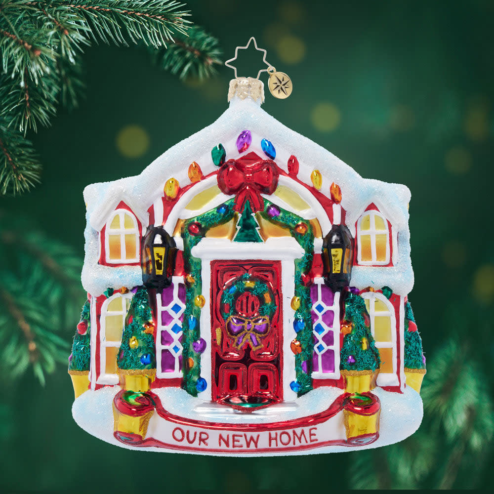 Snow-covered holiday home ornament with festive lights