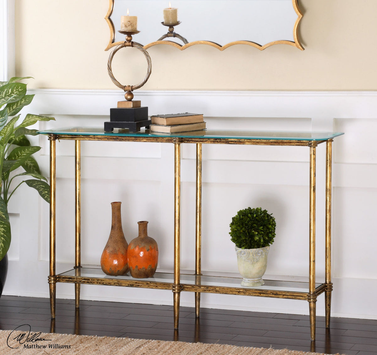 Elenio glass console table with a clear tempered glass top supported by an open metal frame base in black finish.