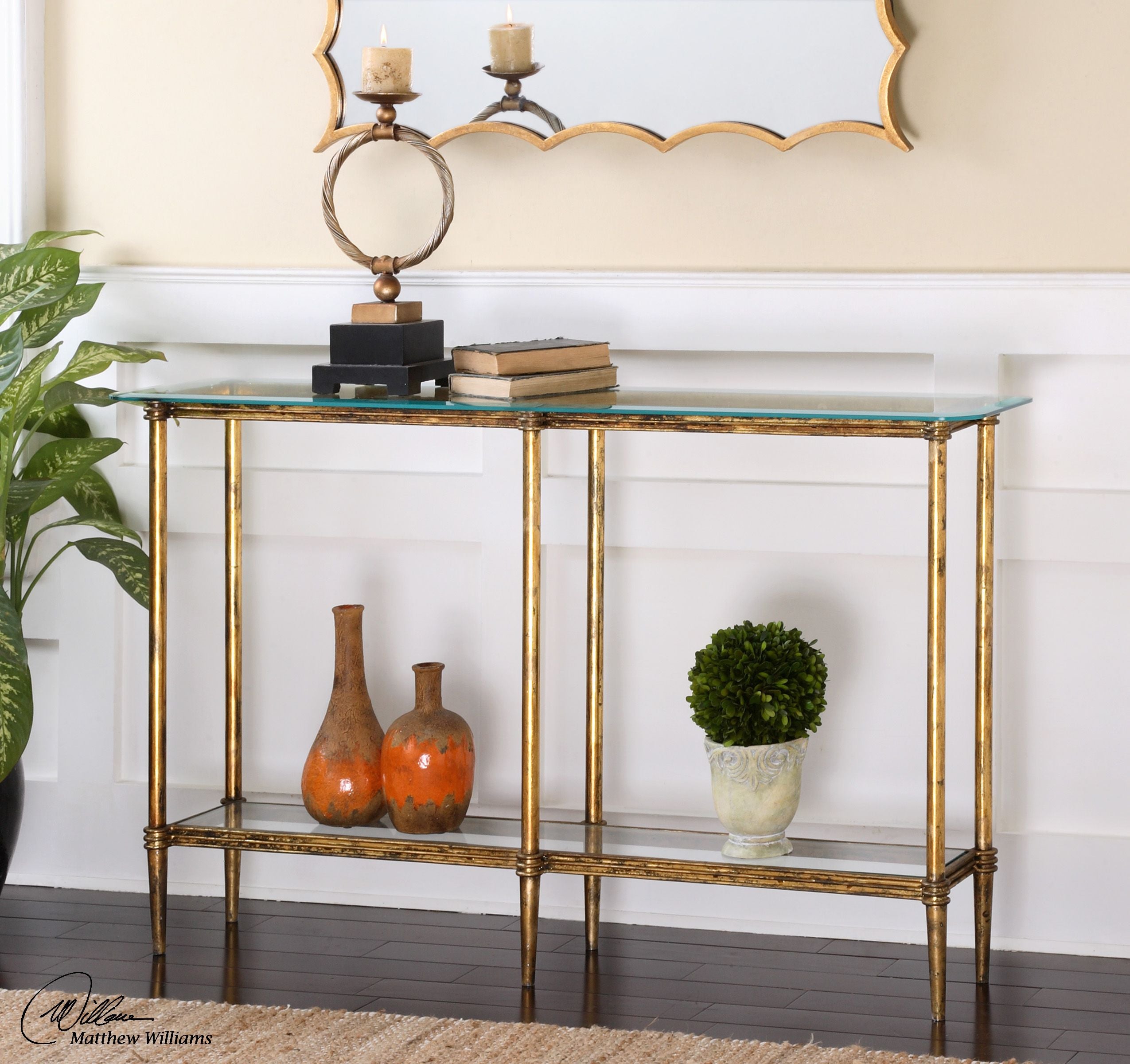 Elenio glass console table with a clear tempered glass top supported by an open metal frame base in black finish.