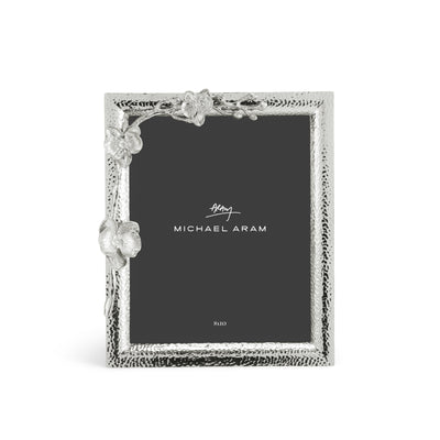 White orchid-patterned photo frame holding an 8x10 picture