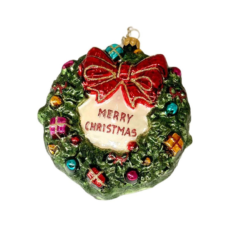 Hand-blown glass wreath ornament with a red bow, colorful presents, and "Merry Christmas" text.