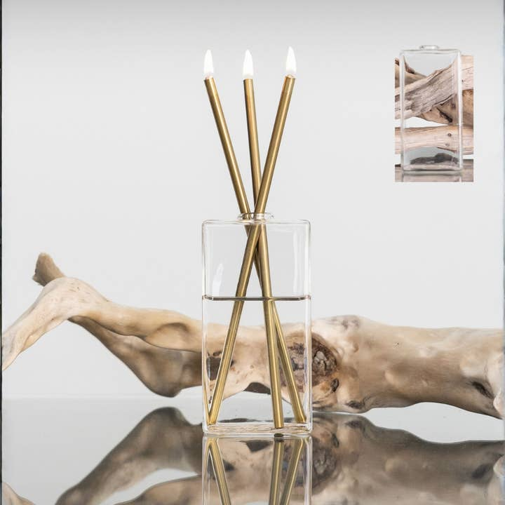 Bondi rectangular clear glass vase with three gold Everlasting Candles lit inside.