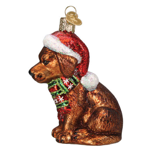 Holiday Chocolate Labrador Pup glass ornament wearing a red Santa hat and a green plaid scarf.