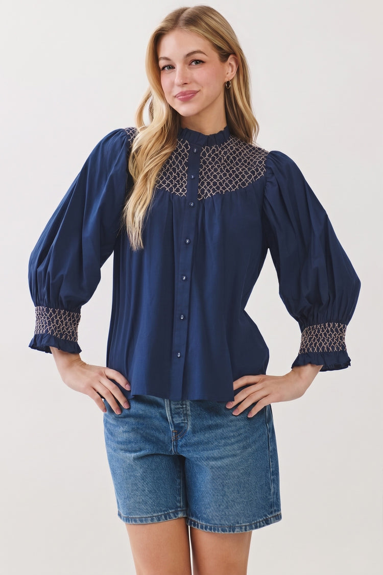 Woman wearing a navy blue Jenny Embroidered Button Down Blouse Top with denim shorts.