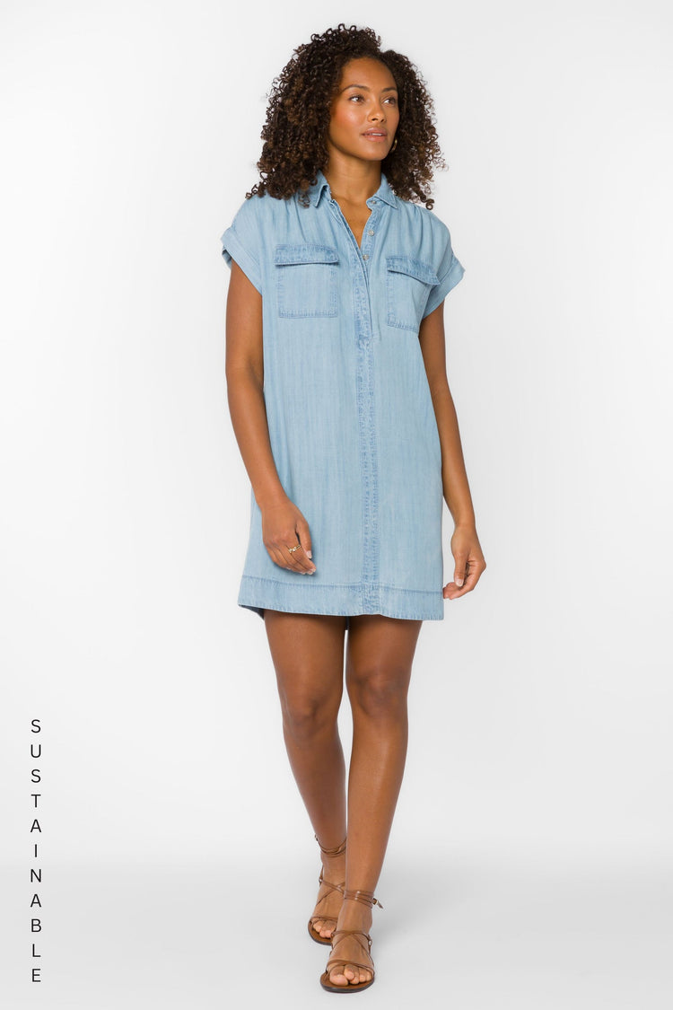 Woman wearing the Starla Dress, a light blue TENCEL™ lyocell mini shirt dress with chest pockets.