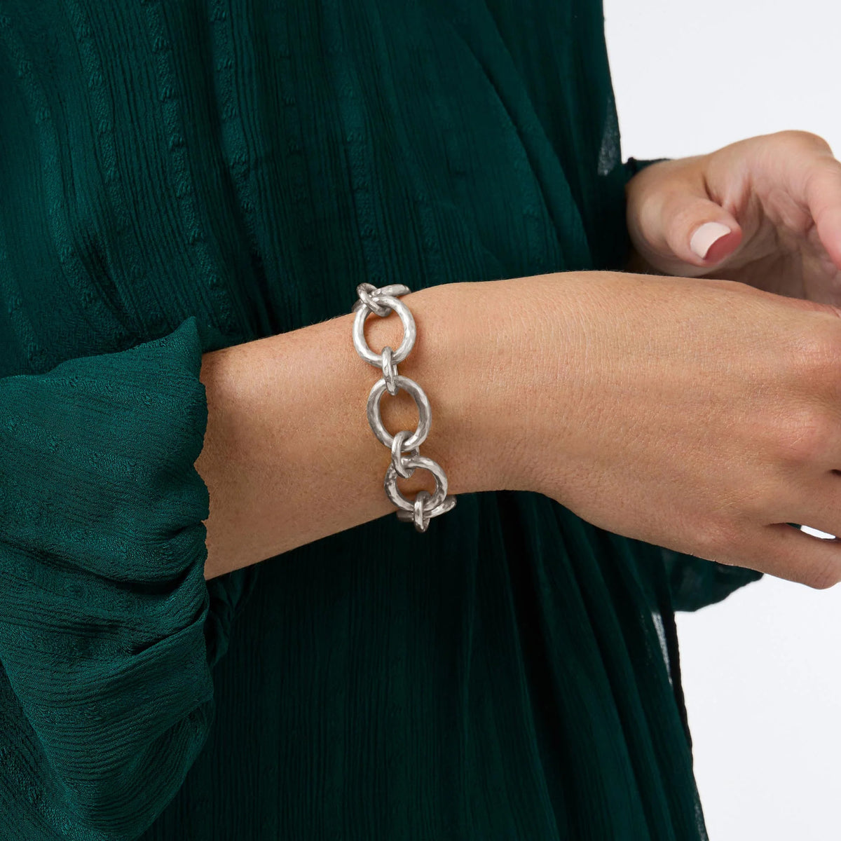 A person wearing the Catalina silver demi link bracelet with a green textured dress.